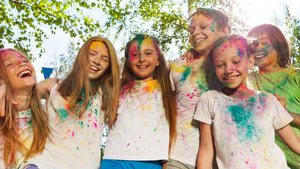 Des enfants lors d'un événement scolaire avec de la poudre de couleur sur eux
